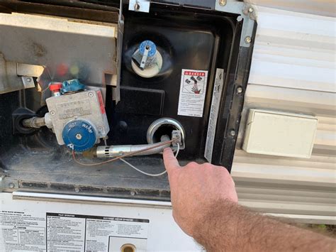 How do I adjust the flame on my RV water heater?