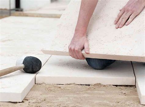How do you prepare ground for laying slabs?