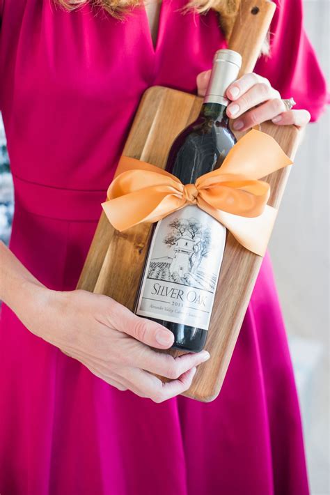 How do you present a bottle of wine to a hostess?