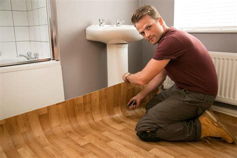 How do you start laying vinyl flooring in a room?