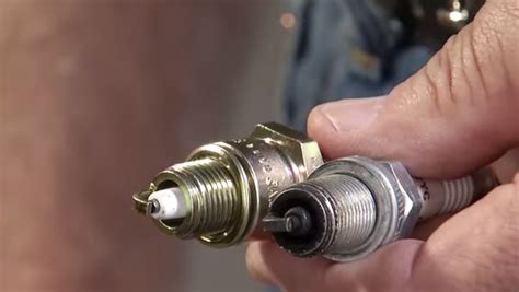 What are the symptoms of a bad spark plug in a lawn mower?