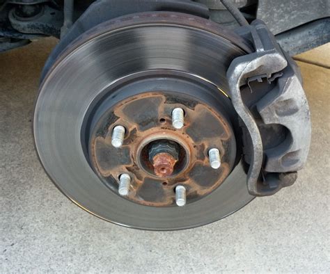 What should be done first after installing new disc brake pads?